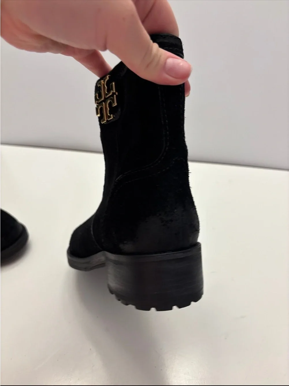 Tory Burch black suede Eloise flat booties with a prominent gold-tone metal logo